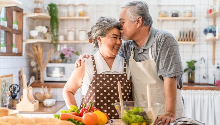 Couple in kitchen cooking